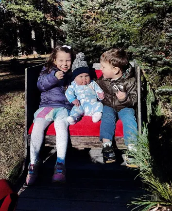 Cora, Callan, and Dawson Clancy at a Christmas tree farm