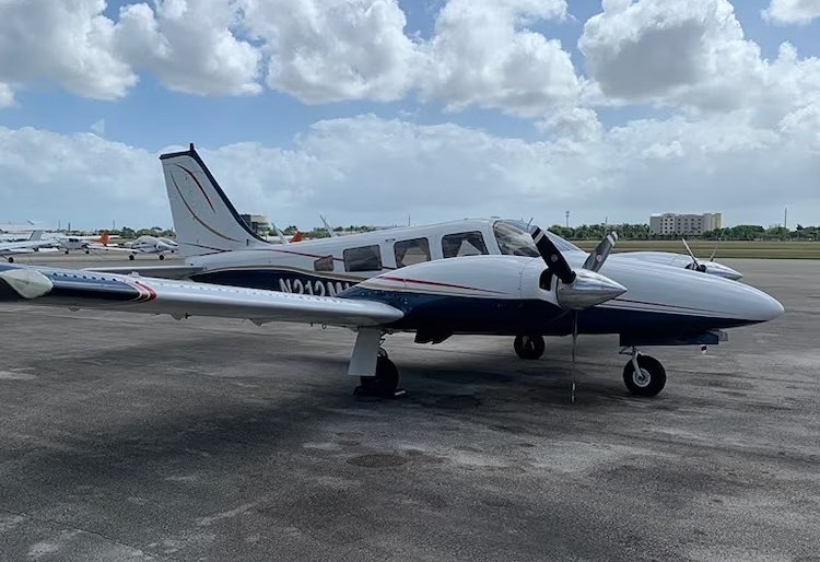 Single-engine airplane parked on an airfield.