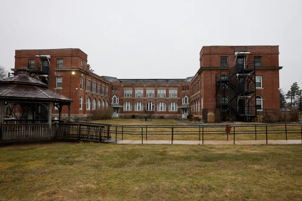 The Saunders Building at Tewksbury State Hospital, a red brick U-shaped building with a large courtyard.