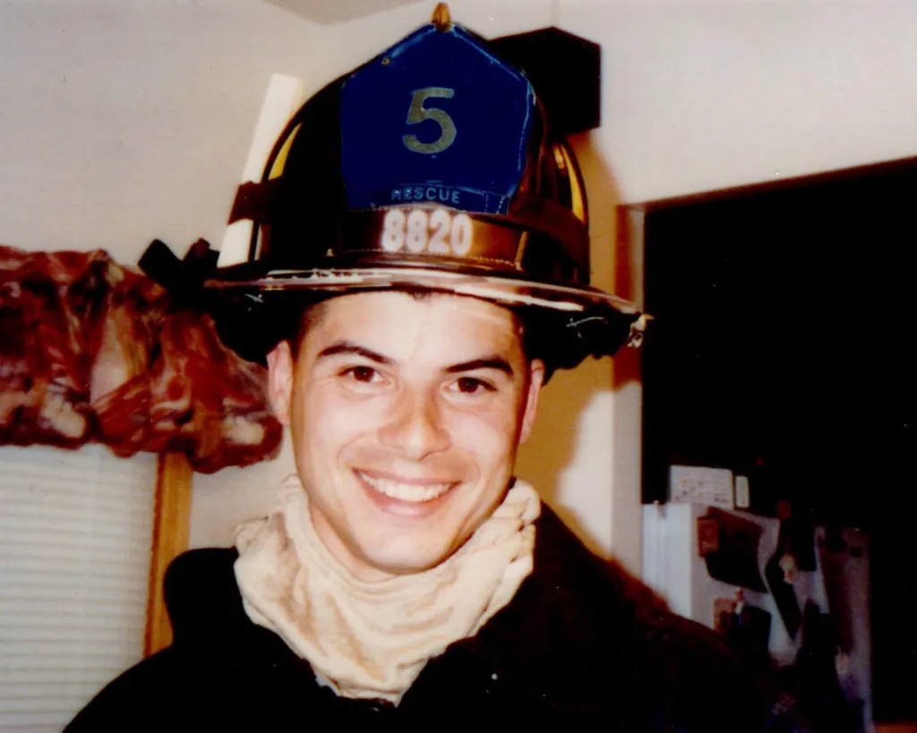 New York firefighter Jeffrey Palazzo smiling in his helmet and gear.
