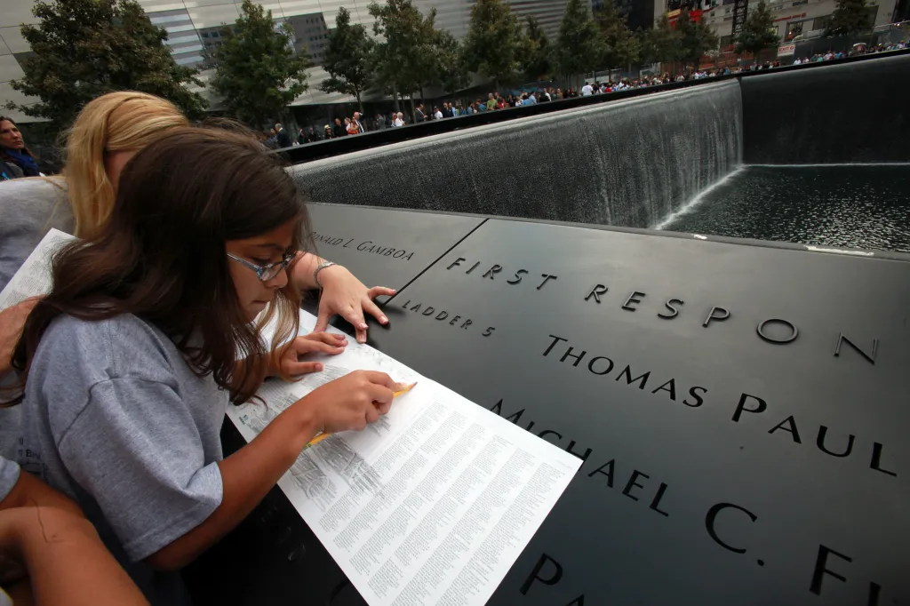 Samantha Palazzo tracing the name of her father, Jeffrey Palazzo, on the September 11th Memorial in New York.