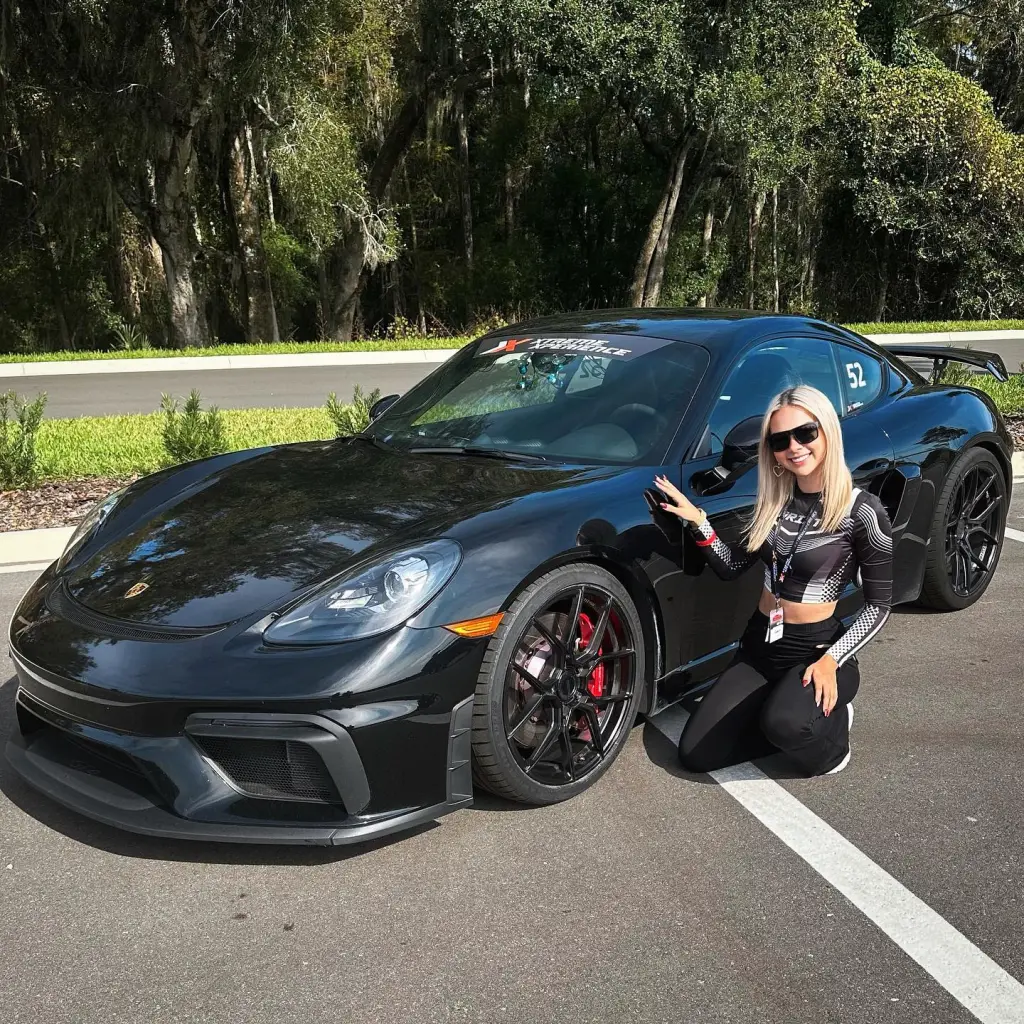 Lexi kneeling next to a black 2019 McLaren.