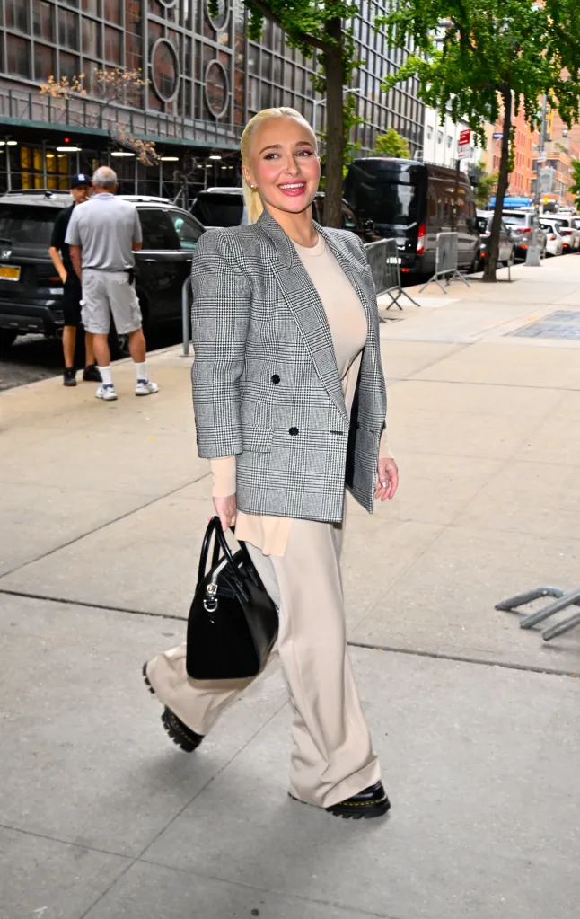 Actress Hayden Panettiere on the street in a grey plaid blazer, beige top, and wide-leg trousers.