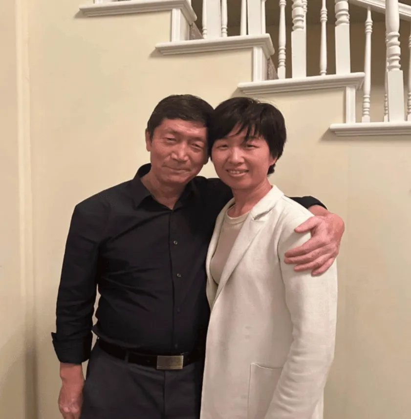 Silvia Zhang and Guojun Xuan stand together indoors.