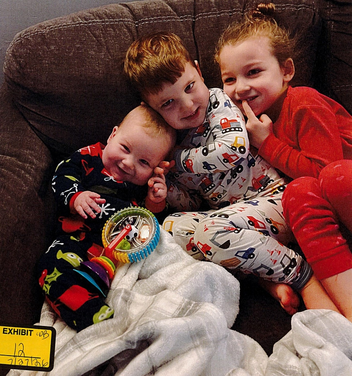 The Clancy children, from left, Callan, Dawson and Cora, sitting on a couch.