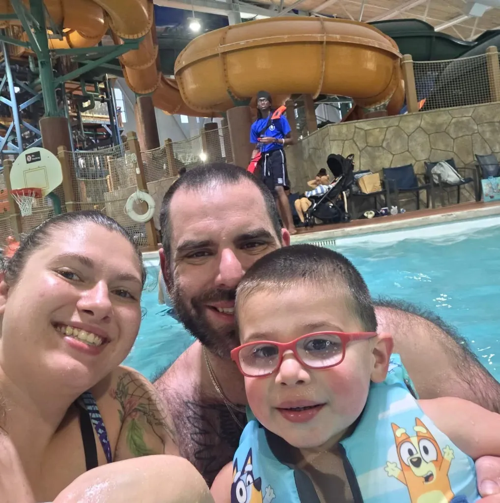 Metallica Rose Harrison and her husband Charles Harrison pose with their son in a swimming pool.