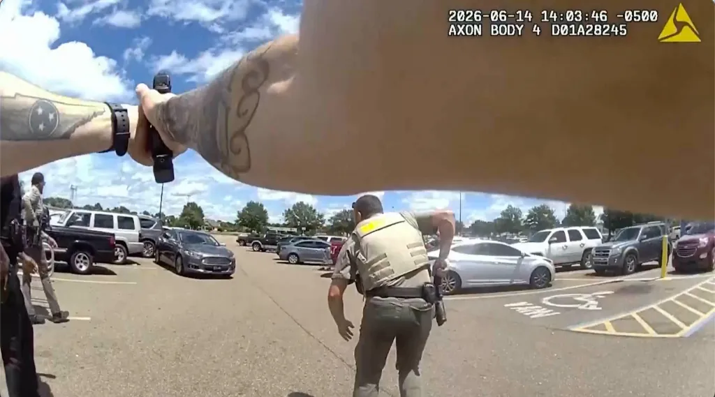 Body-camera footage shows an officer pointing a gun in a parking lot, with another officer nearby.