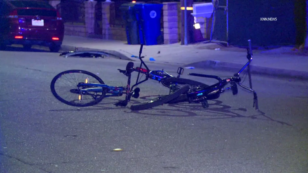 Damaged bicycles lie on a street at the intersection where a vehicle struck bicyclists.