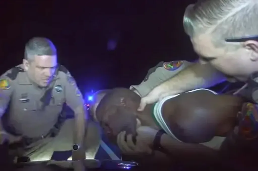 Police officers detaining Jaythan Lawrence Gilder.