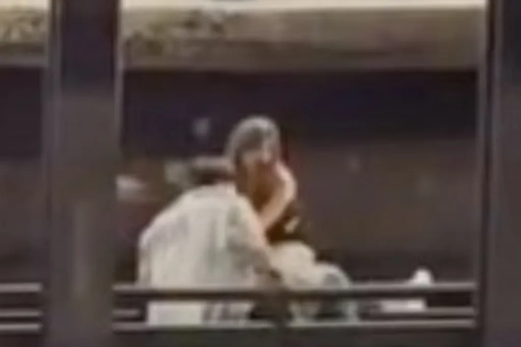 Two blurred figures on subway tracks.