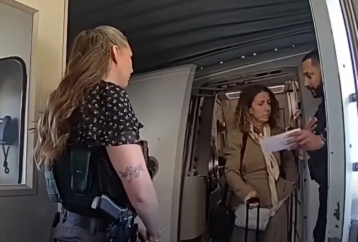Police bodycam still of Irene Miller being arrested while deboarding a flight.