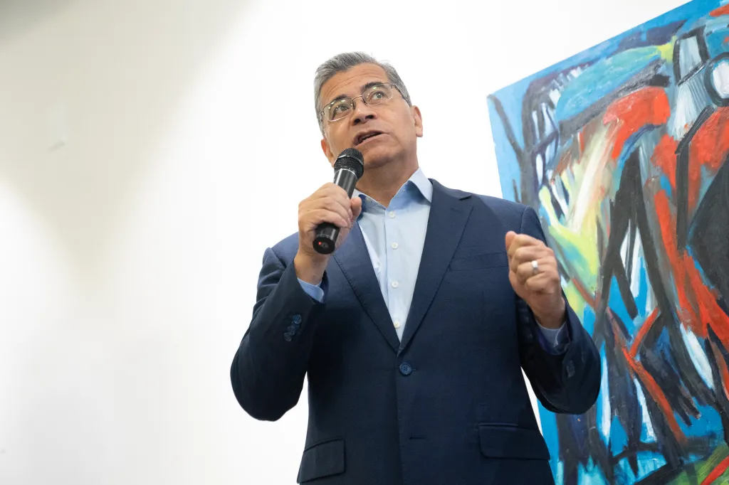 California gubernatorial candidate Xavier Becerra speaks into a microphone during a campaign event.