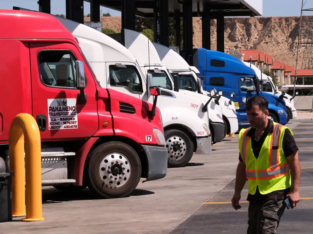 Semi-trucks parked at a truck stop as fuel costs continue to rise.