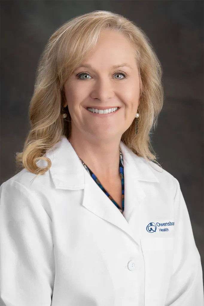 Stacey Fazenbaker wearing a white doctor's coat with the Owensboro Health logo.