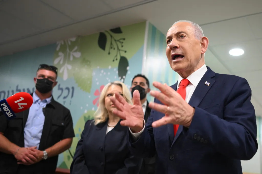 Israeli Prime Minister Benjamin Netanyahu speaks to the media next to his wife Sara at a polling station in Jerusalem.