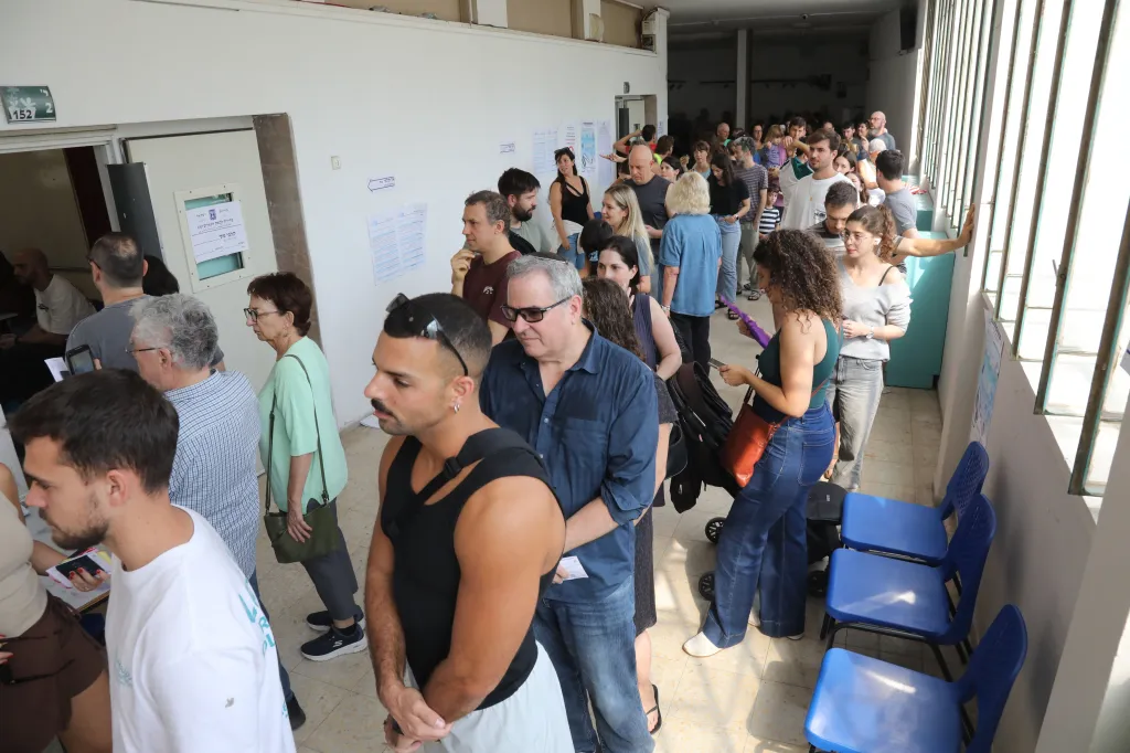 Voters wait in line to cast their ballots at a polling station.