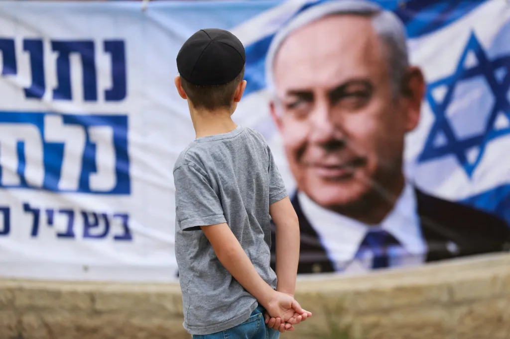 A child looks at a banner depicting Israeli Prime Minister Benjamin Netanyahu.