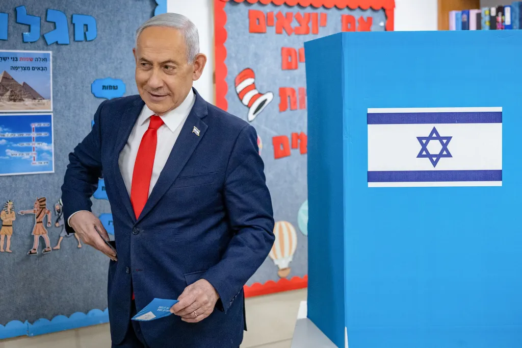 Israeli Prime Minister Benjamin Netanyahu holds a ballot next to a polling booth during legislative elections in Jerusalem.