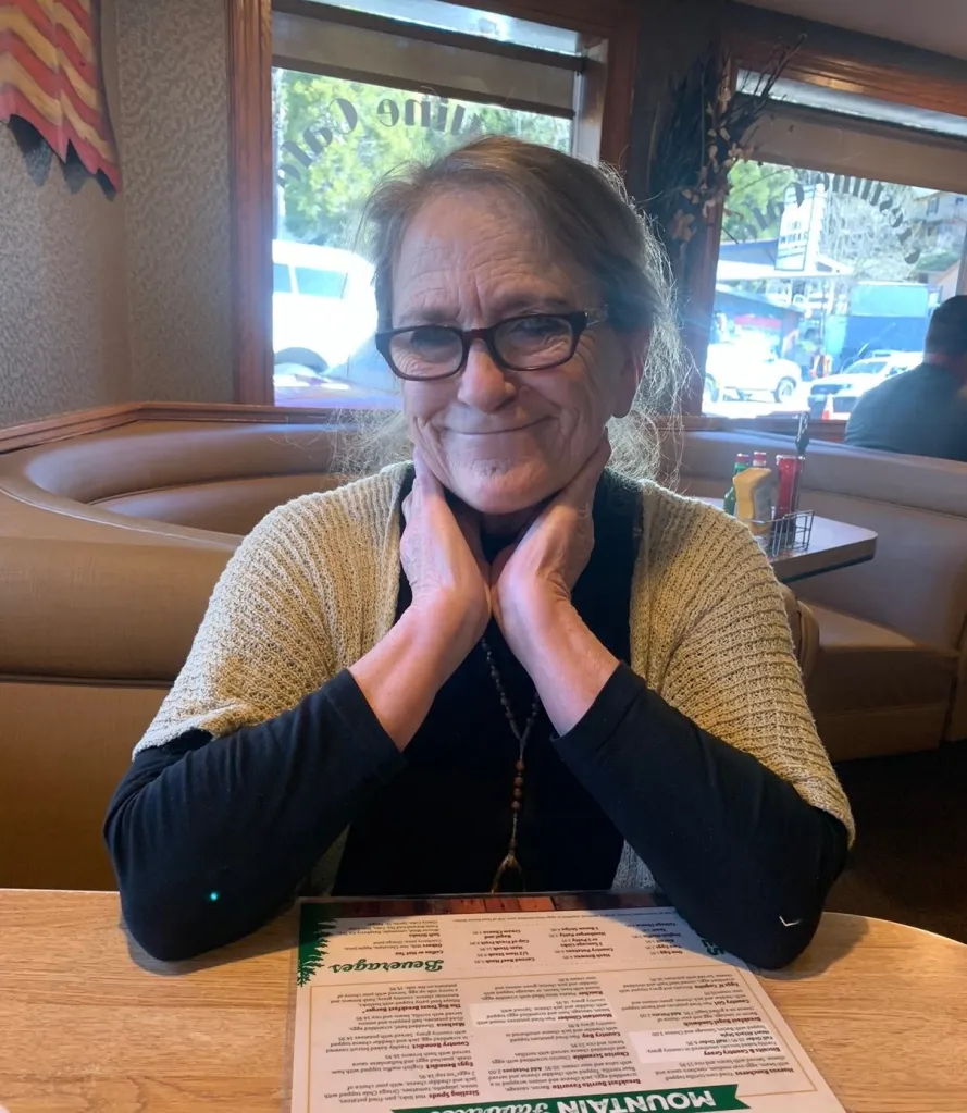 Theresa Garcia, 71, seated at a restaurant table with a menu.