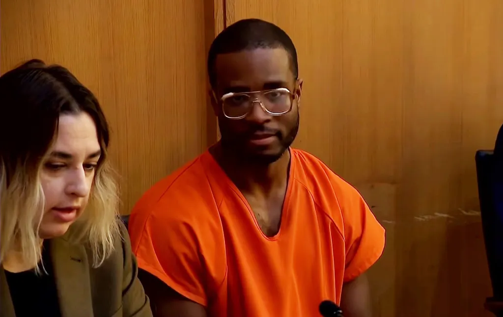 Tamarius Davis in court wearing an orange jumpsuit and glasses.