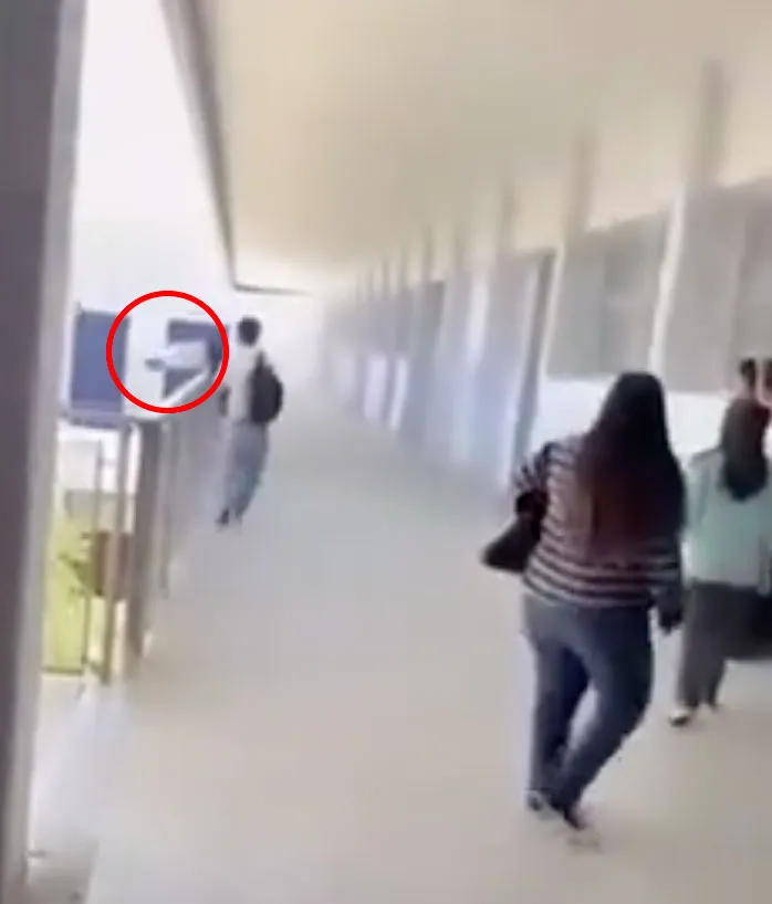 A student jumping over a fourth-floor balcony railing at Benjamin Franklin High School.