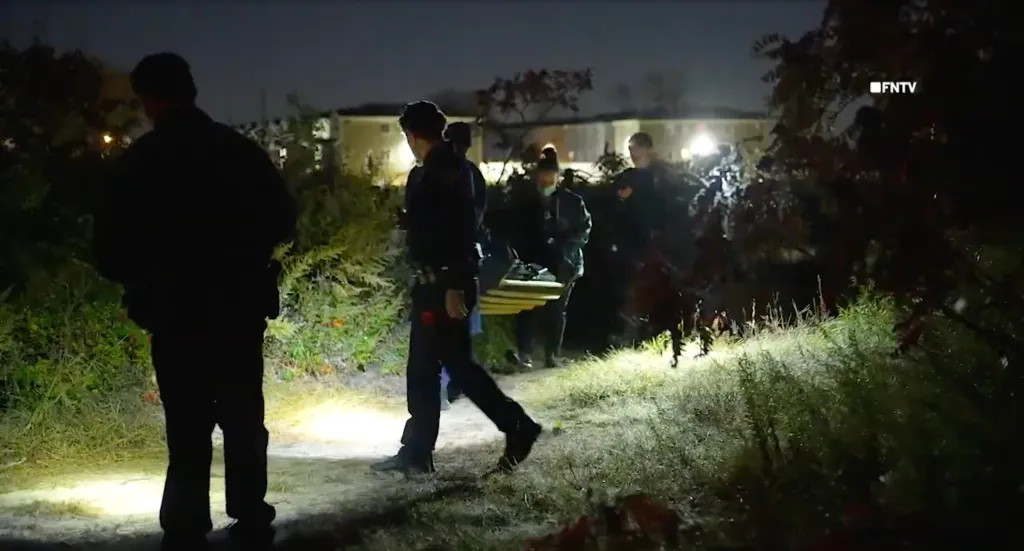 Police officers investigating the scene where human remains were discovered at night in Queens.