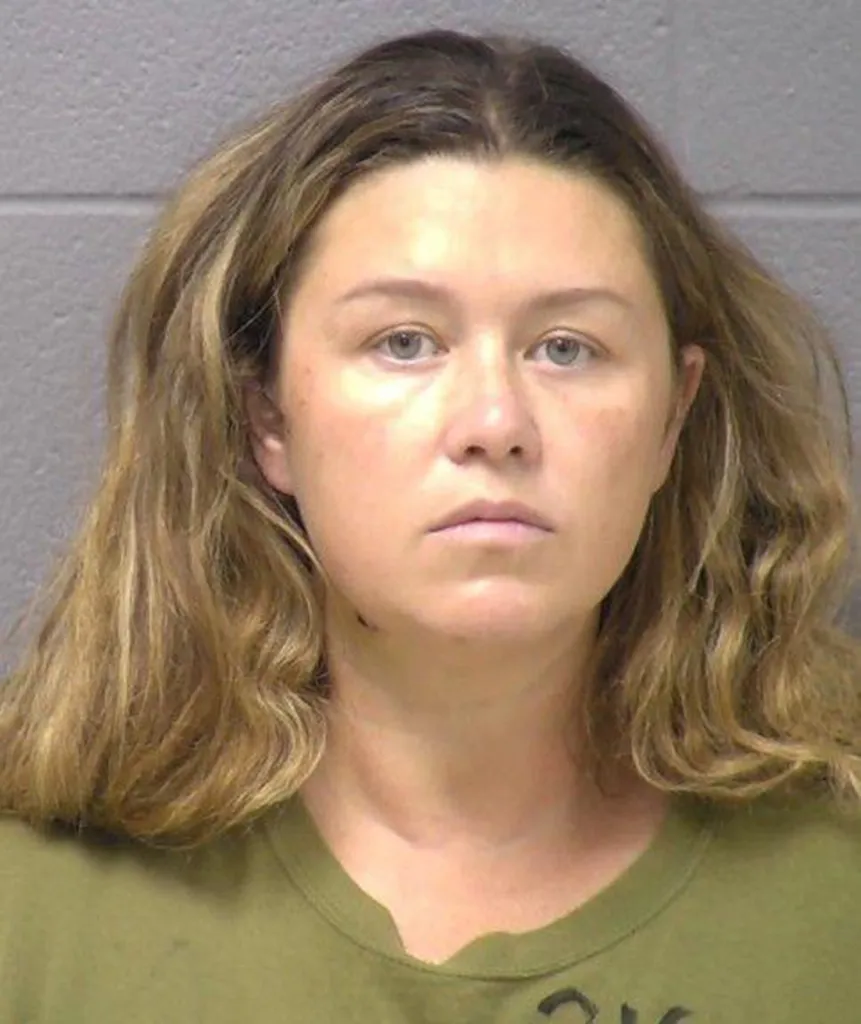 Mugshot of Corie A. Walsh, a woman with long, light brown hair, wearing a green shirt, looking directly at the camera.