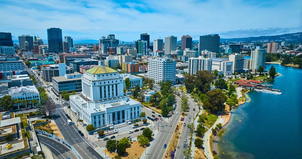 Aerial view of Oakland, California, featuring the Alameda County Superior Courthouse in the foreground and downtown skyscrapers in the background.