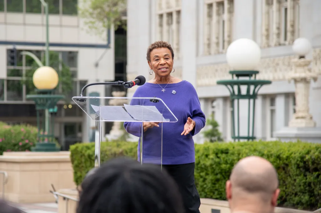 Oakland Mayor Barbara Lee addresses the crowd at a podium.