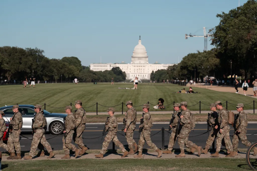 A National Guard unit patrols the National Mall in Washington, with the U.S. Capitol in the background.