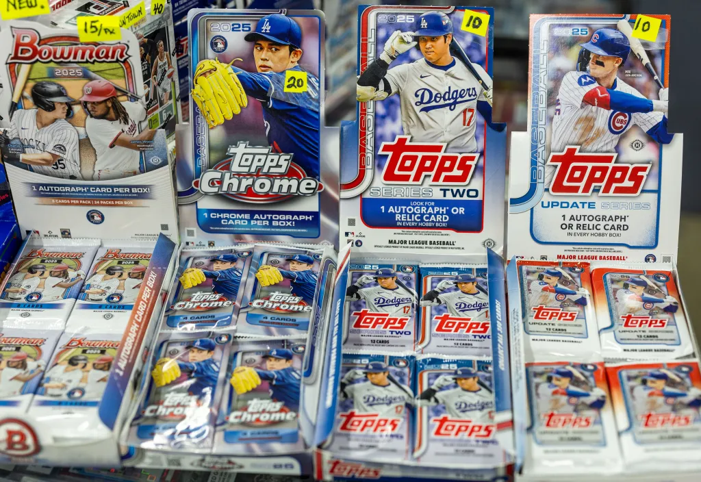 Unopened packs of Topps and Bowman baseball cards displayed on a vendor's table.