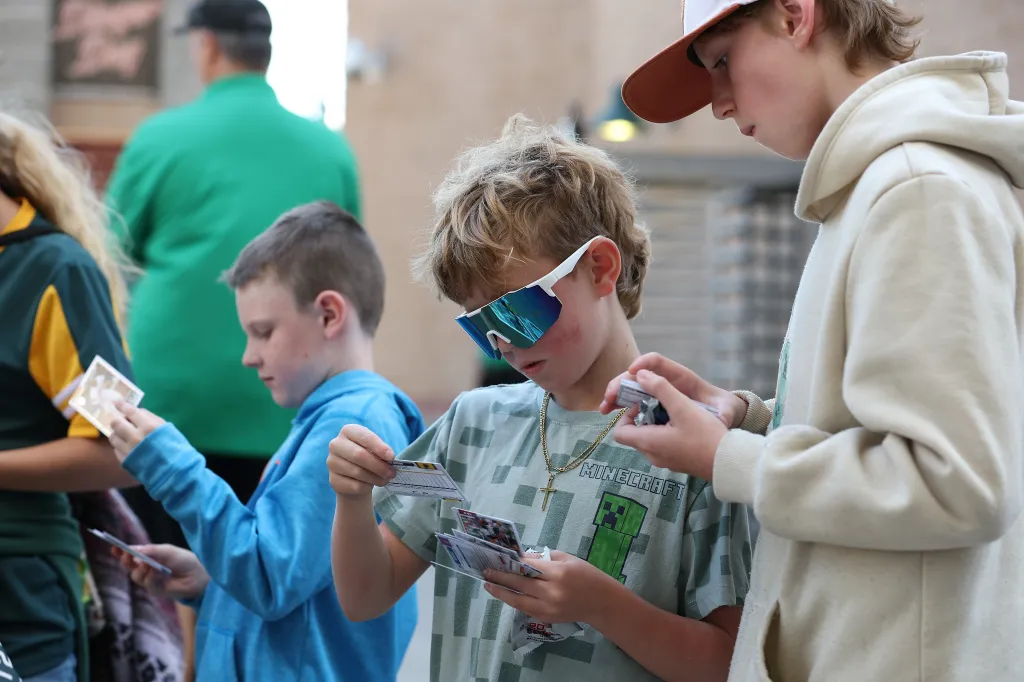 Young fans opening and looking at baseball cards.