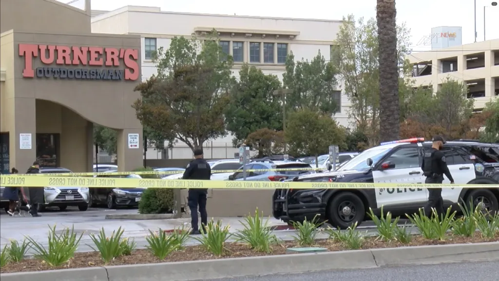 Police tape and officers in front of Turner's Outdoorsman store where a teenager was killed.