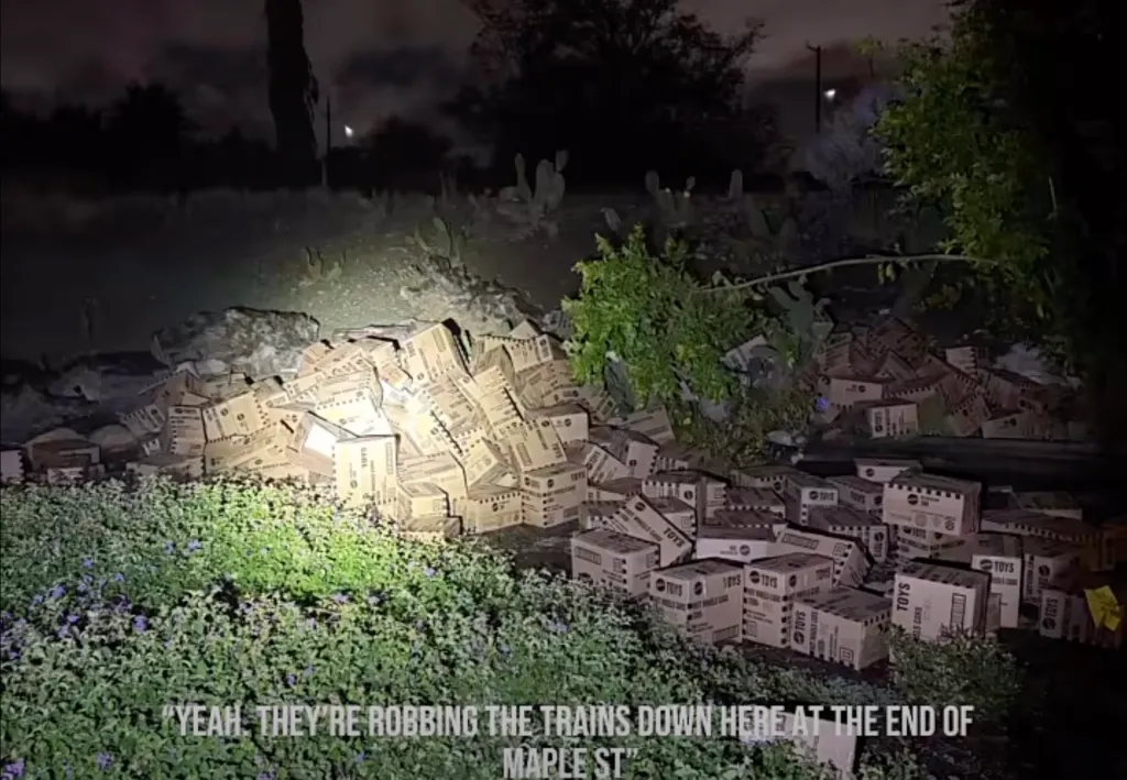 Stolen boxes of Hot Wheels cars recovered by police, piled up outdoors at night.