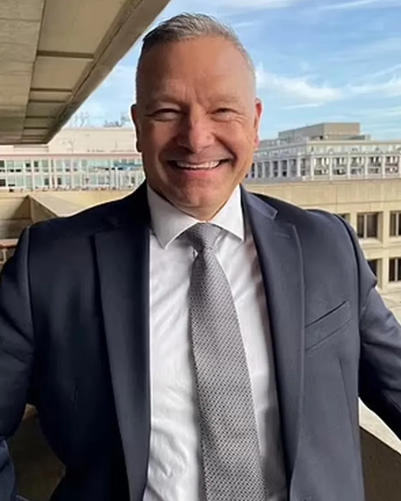 Bradley Benavides wearing a suit and tie while smiling outside.