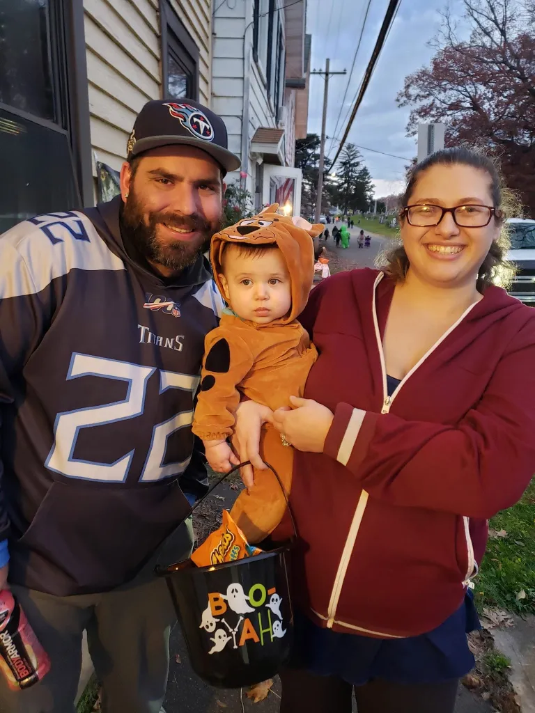Metallica Rose Harrison and her husband Charles Harrison hold their son in a Halloween costume.