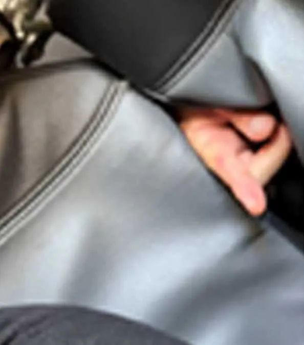 A close-up, blurry photo showing Jonathan Alan Lefman's hand reaching between airplane seats.