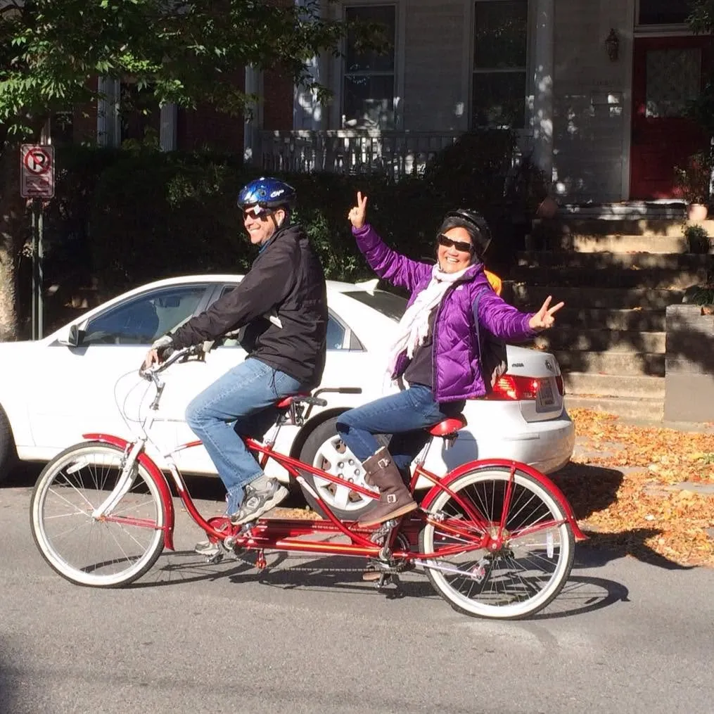 Terry Ward and his wife, Laura, ride a tandem bicycle together outdoors.