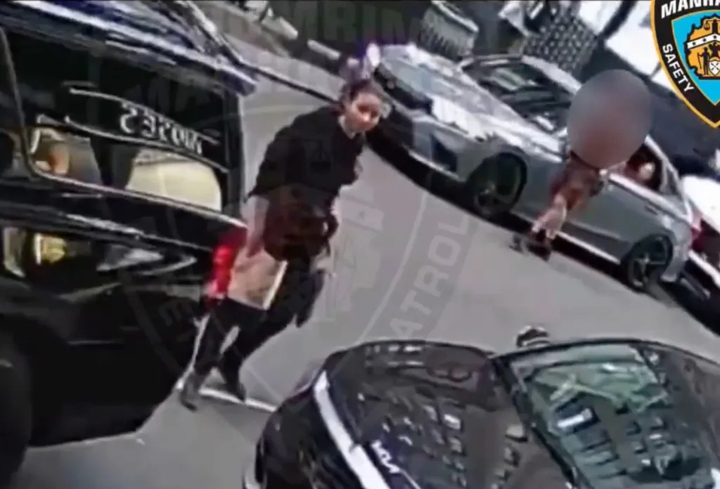 Surveillance footage shows a woman walking between cars on a street.
