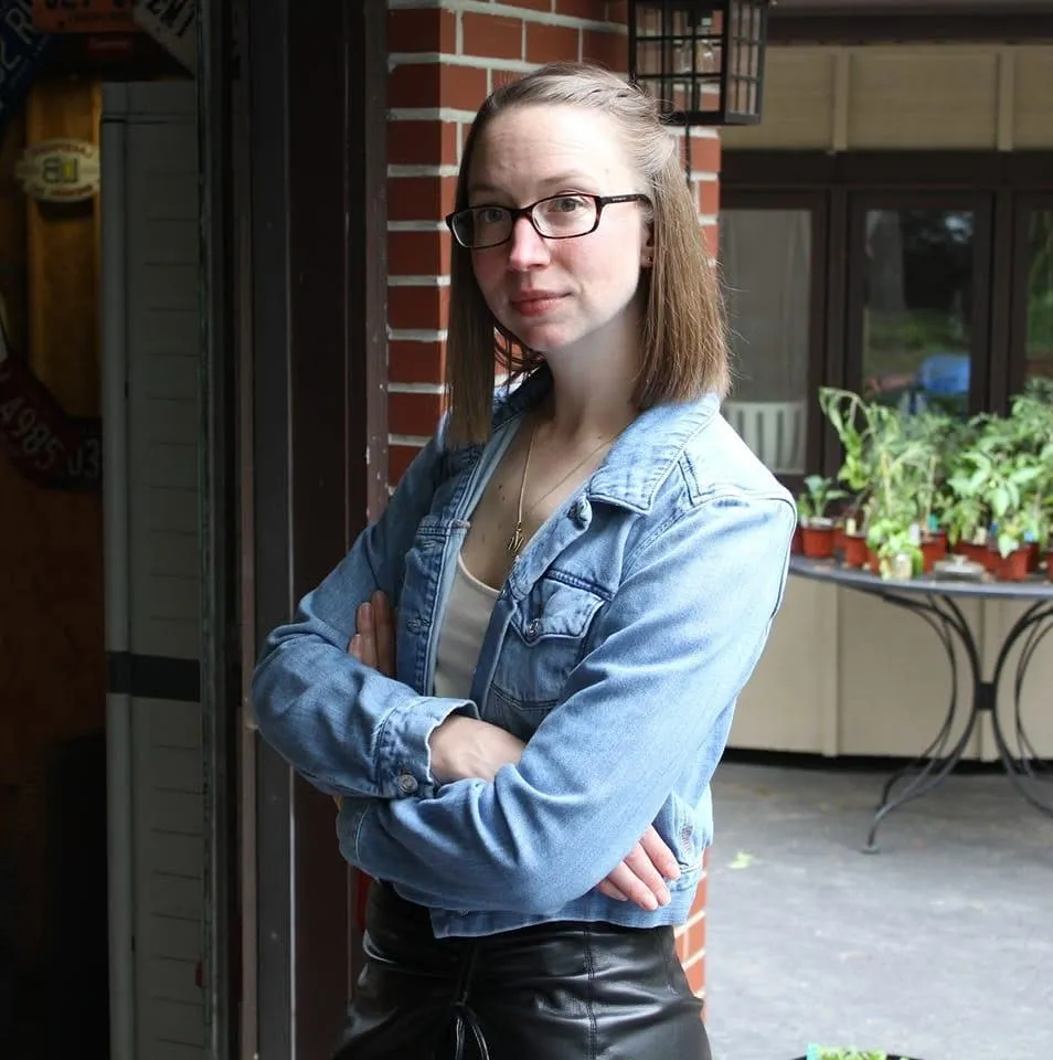 Nicole Heiser wearing glasses and a denim jacket.