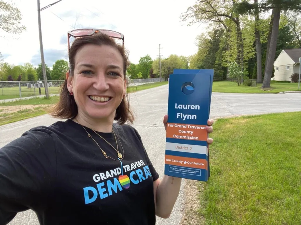Grand Traverse County Commissioner Lauren Flynn holding campaign door hangers.