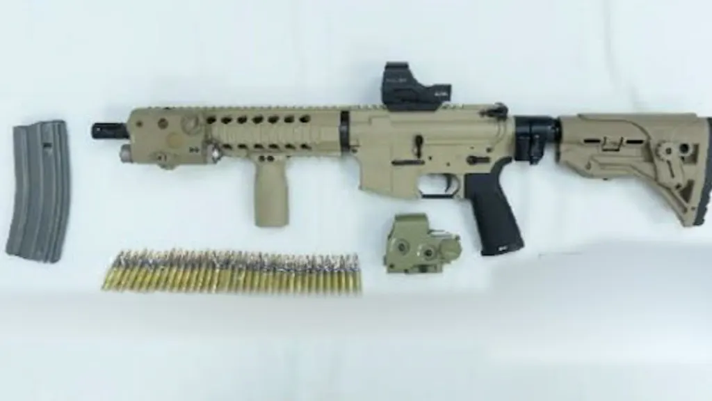 A tan assault rifle, a separate magazine, a row of ammunition, and optical attachments displayed on a flat surface.