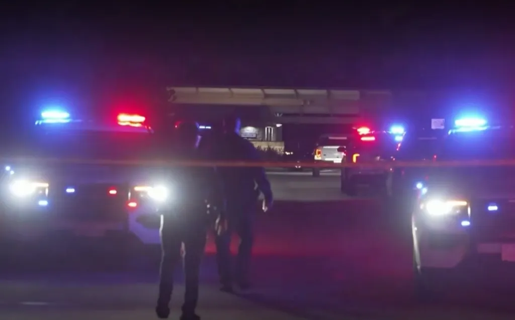 Police vehicles with flashing lights and crime scene tape at Fall Creek Sports Complex after a shooting.