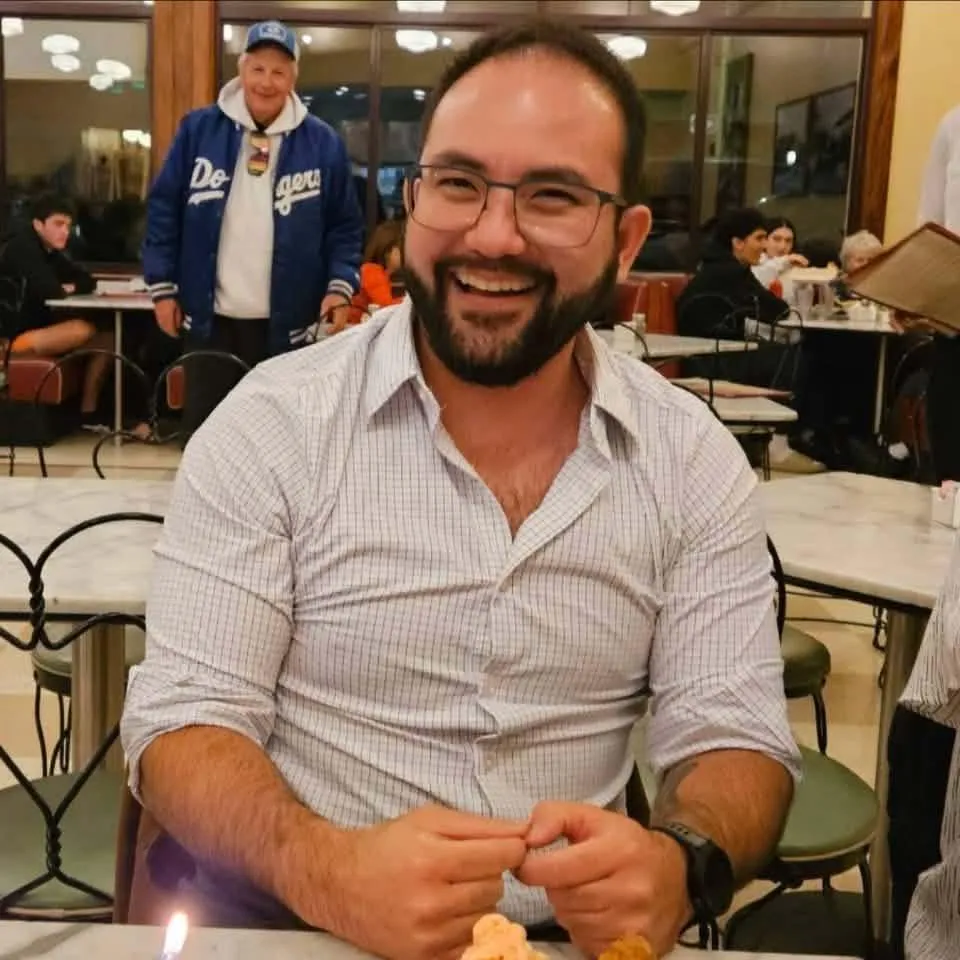 Jonathan McKinsey smiling while sitting at a table in a restaurant.