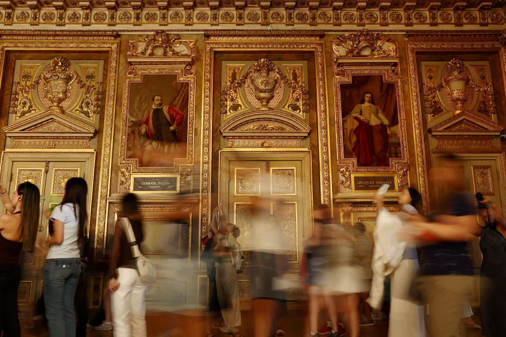 Visitors walk in the Apollo Gallery at the Louvre Museum following its reopening.