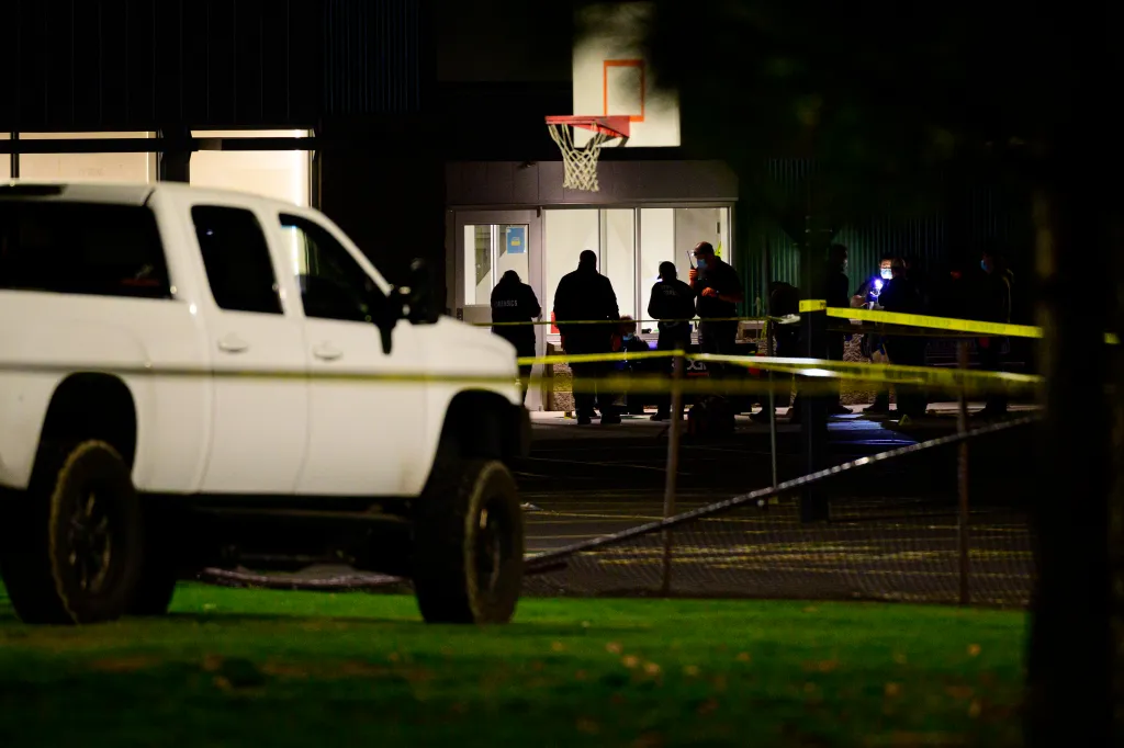 Crime Scene Investigators gather evidence at Silver Rail Elementary School in Bend, Oregon, behind a white pickup truck.