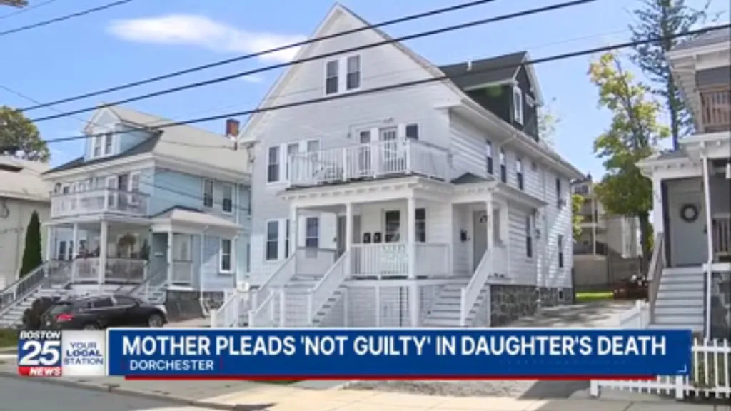 Exterior view of a multi-family white house in a residential neighborhood, with a news chyron at the bottom reading "MOTHER PLEADS 'NOT GUILTY' IN DAUGHTER'S DEATH."