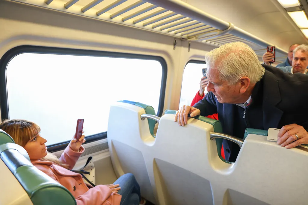 Bruce Blakeman talks to a passenger while riding the LIRR.