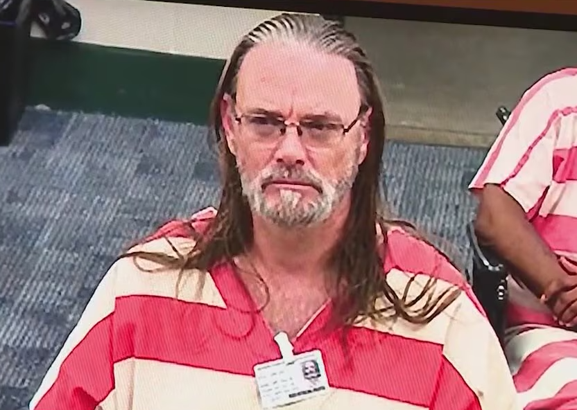 Dwain Hall wearing a striped jail uniform in court.